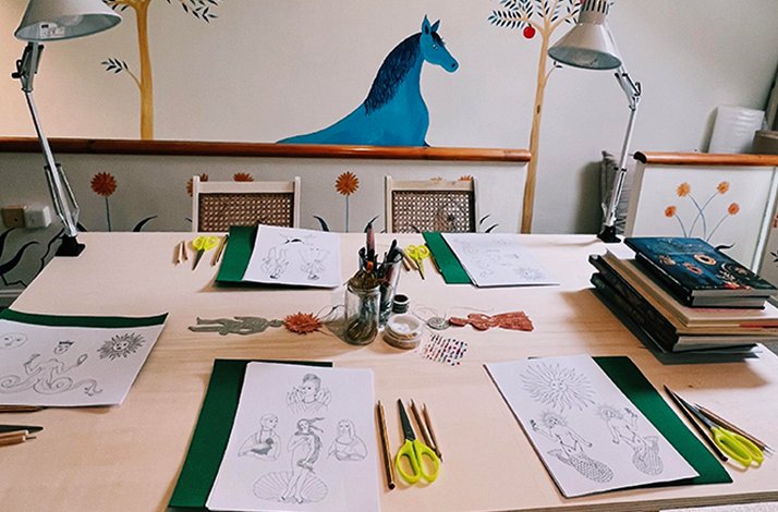 Brianda Fitz-James Stuart's Madrid studio worktable laid out with stencil designs, tools, and green felt sheets ready for an embossing class.