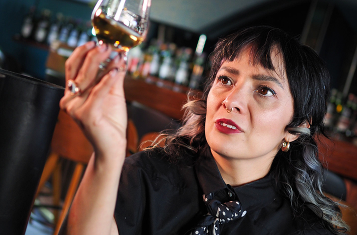 Whisky expert Yésica Flores examining a glass during a blind tasting, guiding guests through aromas, texture, and flavor.