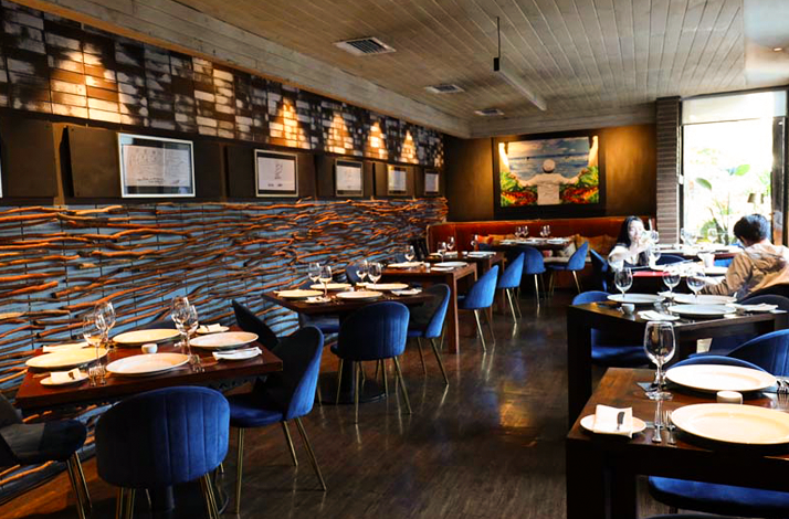 Interior view of Aquí Está Coco restaurant, set for a seafood-focused dining experience.