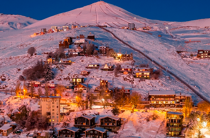 Mountain resort buildings and ski runs overlooking the Andes during a Valle Nevado day experience.