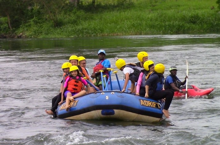 A rafting group enjoying the serene stretches of the Nile River with scenic green surroundings.