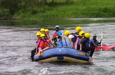 A rafting group enjoying the serene stretches of the Nile River with scenic green surroundings.