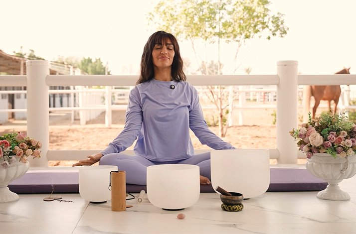 A smiling woman meditating on the terrace