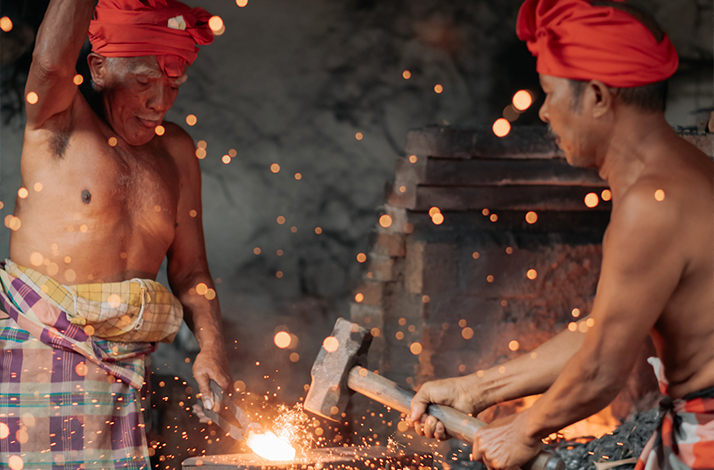 Master keris maker forging a blade in a traditional Balinese workshop.