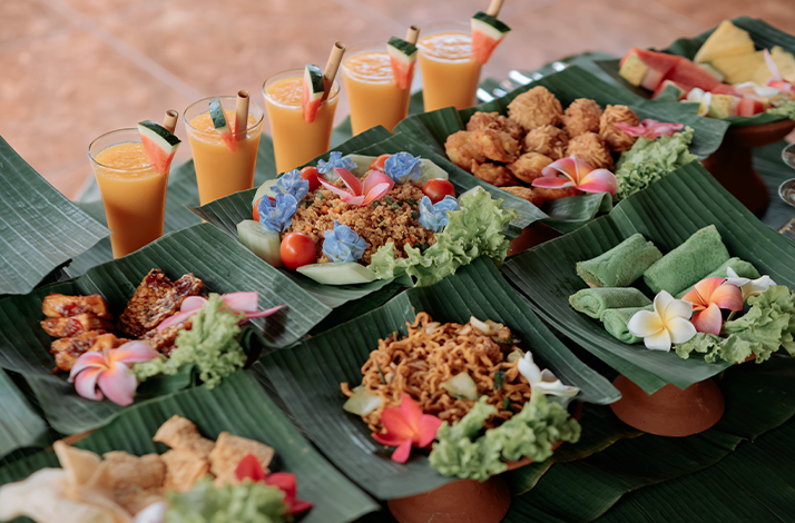 Traditional Balinese home-cooked meal served in a family compound with assorted dishes and drinks.