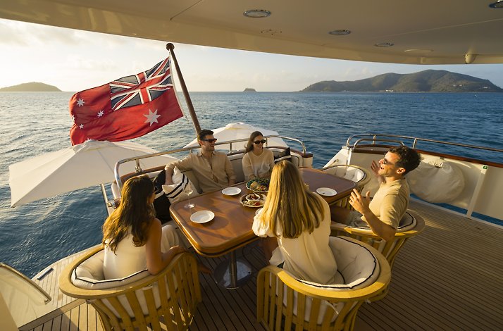 Guests dining aboard a yacht in the Whitsundays.