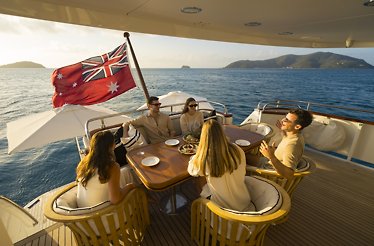 Guests dining aboard a yacht in the Whitsundays.