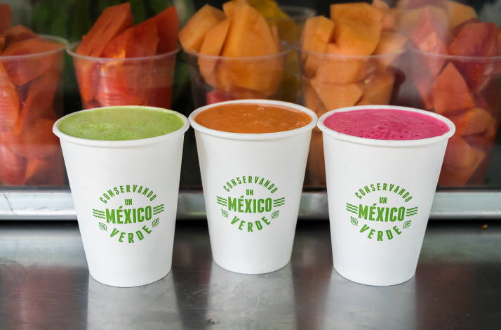 Traditional Mexican fruit-based drinks served in takeaway cups at a local mercado stall in Mexico City.