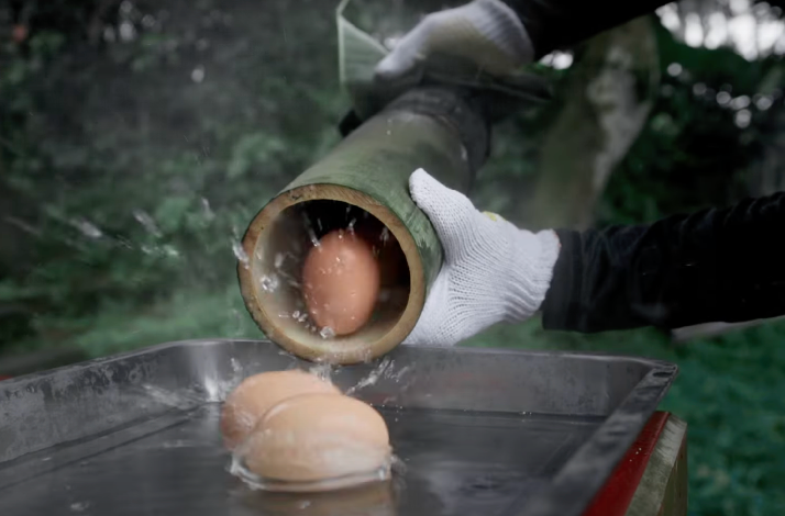 Boiling eggs in a traditional bamboo tube, a unique Balinese cooking method found in Ubud, Bali, Indonesia.