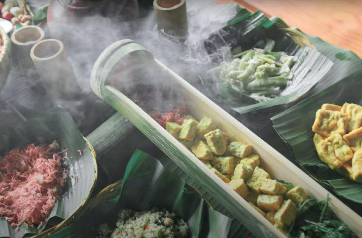 Steaming Balinese dishes served in a split bamboo tube at a traditional cooking class in Ubud, Bali.