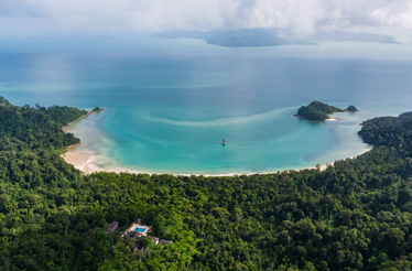 Aerial view of The Datai Langkawi resort nestled in a lush rainforest overlooking the turquoise waters of Datai Bay.