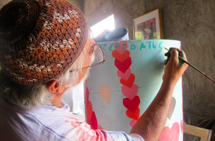Painting a colorful artwork during an intimate contemporary art workshop at Galería Oscar Román.