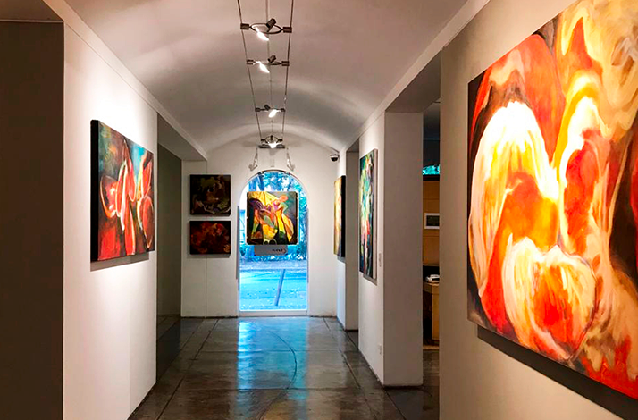 Interior gallery corridor displaying contemporary artworks prior to a private exhibition opening at Galería Oscar Román.