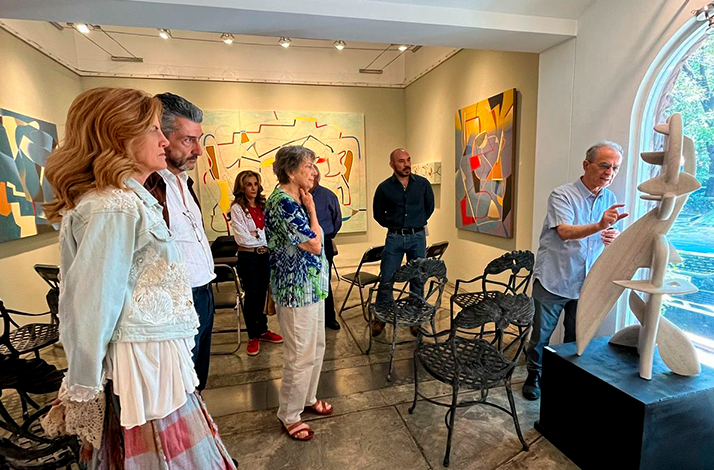 Tour group listening to the guide at Galería Oscar Román.
