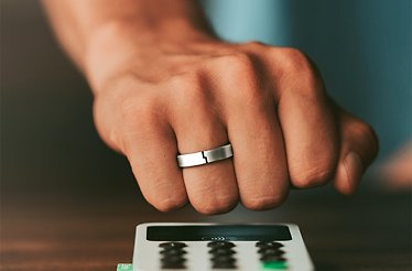 A modern lifestyle image showcasing a sleek TAPSTER wearable ring being used for a contactless payment. TAPSTER blends minimalist design, effortless technology, and the convenience of making contactless payments with a simple movement of the hand.