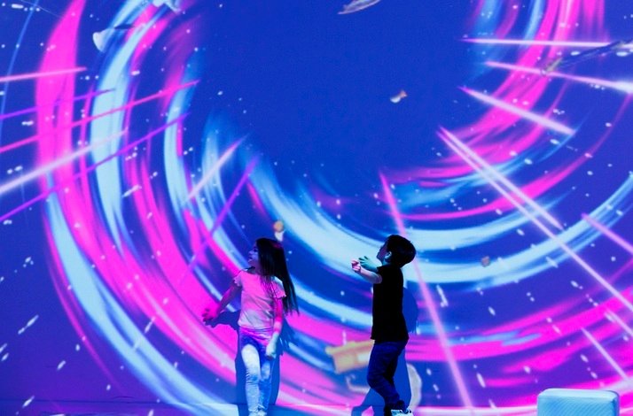 Children in a room with immersive light and color projections at Dream Point.