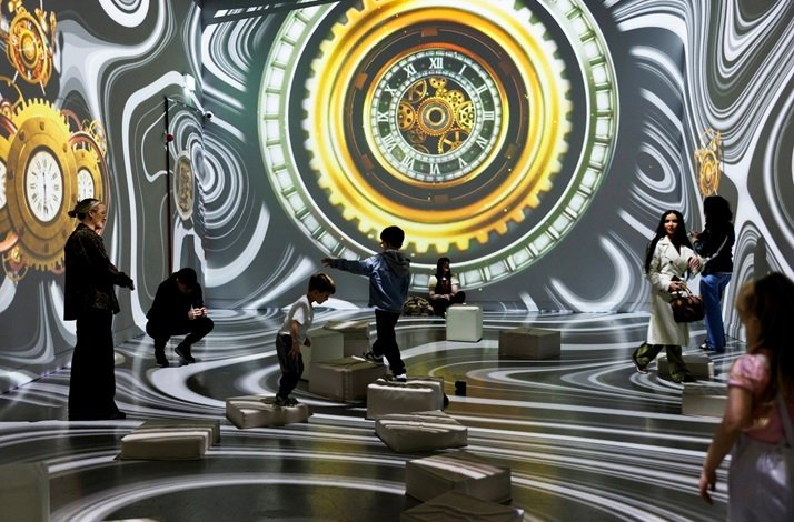 Visitors in a room with clock-themed projections at Dream Point immersive experience.