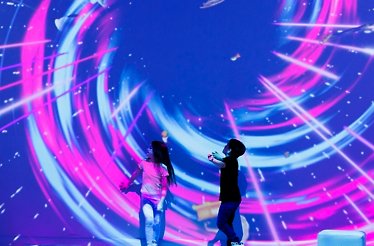 Children in a room with immersive light and color projections at Dream Point.