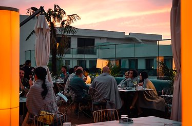 People enjoying dinner during sunset at the open-air dining area of restaurant ZenSushi Eleven.