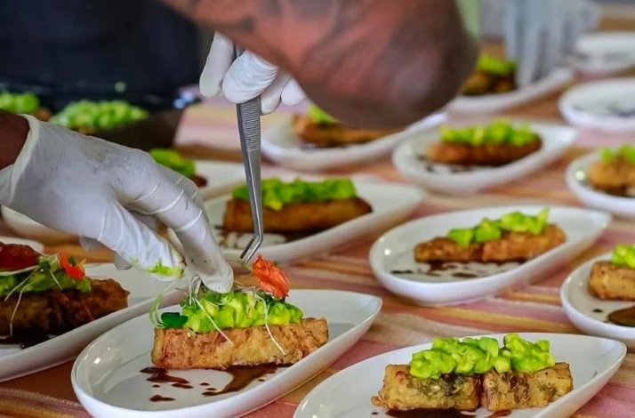 A chef finishing presentation for multiple plates served at a Nairobi Supper Club event.