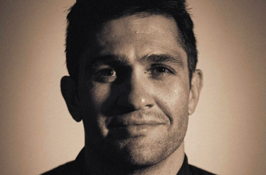 Chef in close-up sepia-toned portrait, wearing a dark jacket, linked to Nairobi Supper Club dining event.