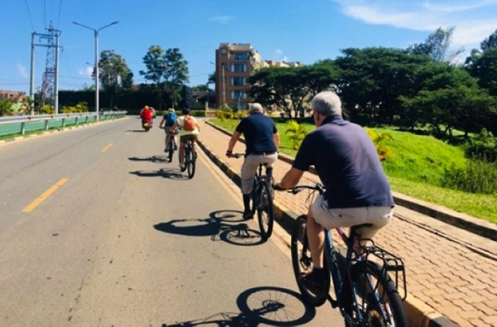Tourists on e-bikes riding through the streets of the Rwandan capital