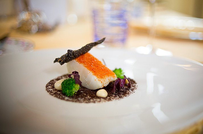 An elegant gourmet fish dish beautifully presented on a wide plate at Ristorante San Domenico.