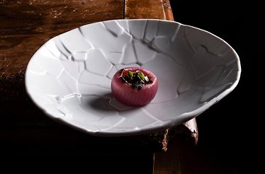 A gourmet stuffed onion served on a textured white plate at Ristorante Mater