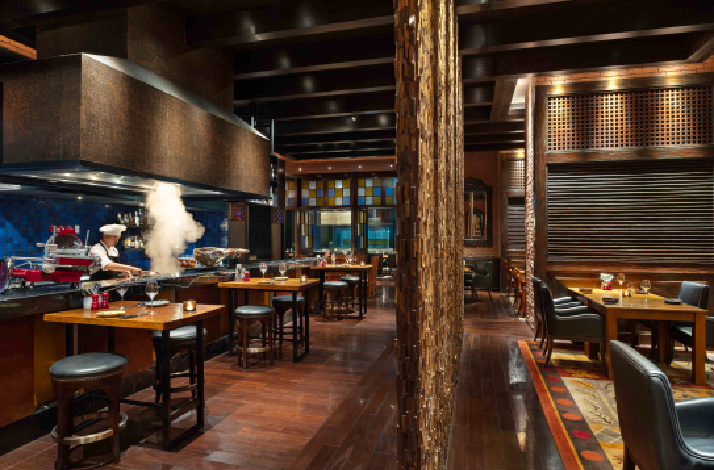 The interior of The Cellar at Grand Hyatt Manila, featuring wooden materials and dim-lit dining areas. 