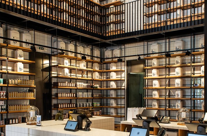 Apothecary interior with Korres-style jars and fragrance products displayed on wooden shelves.