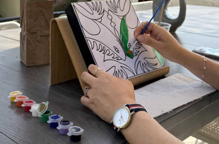 Hands carefully painting a personalized Zapotec animal figure in an intimate studio setting.