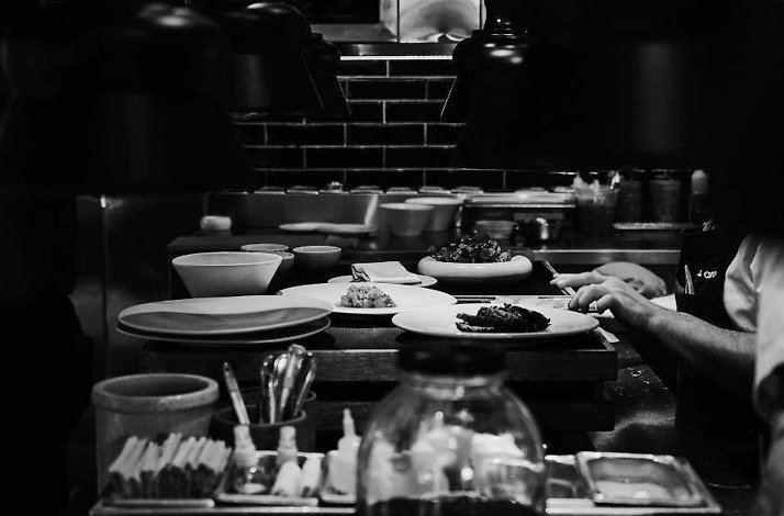 Chefs plating dishes at the open kitchen pass of El Chato, Bogotá