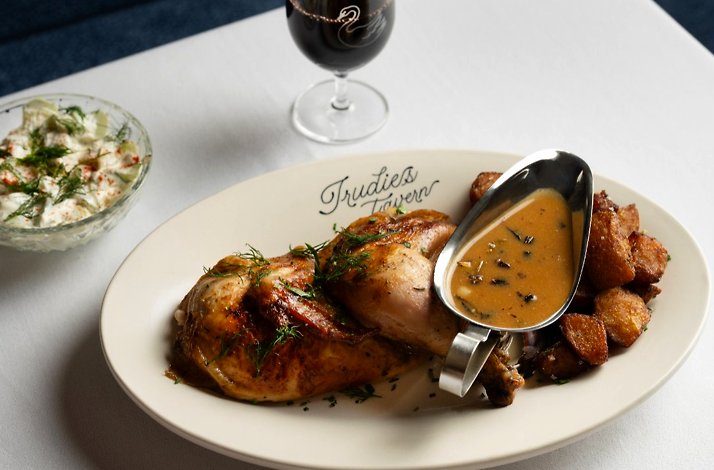Fried chicken with baked potatoes and source paired with a glass of wine served at Trudie's Tavern.