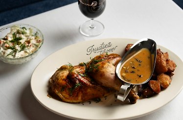 Fried chicken with baked potatoes and source paired with a glass of wine served at Trudie's Tavern.