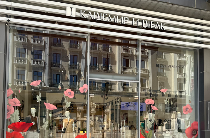 The storefront window of the Cashmere and Silk boutique decorated with large red poppy decals in Tashkent.