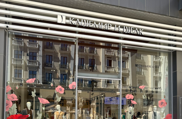 The storefront window of the Cashmere and Silk boutique decorated with large red poppy decals in Tashkent.