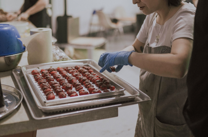Chocolate strawberry preparation in production lab.