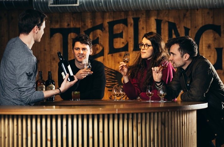 A group of people sitting together sampling and tasting a selection of wines.