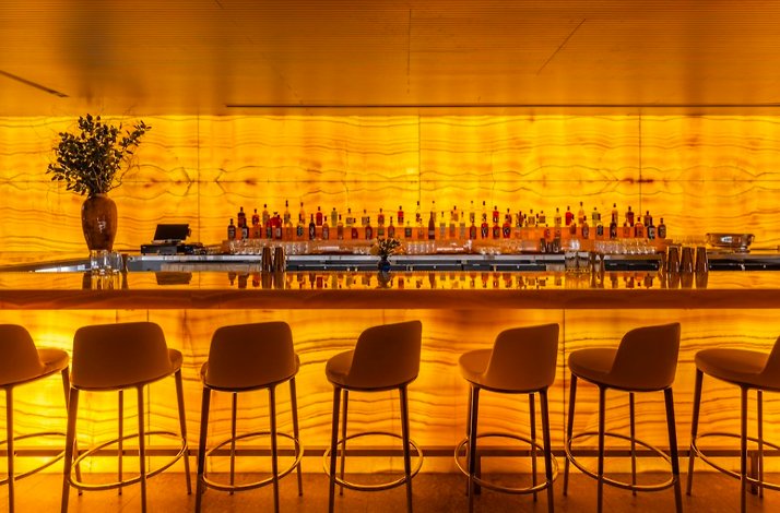 Bar counter at Marea Beverly Hills lit up with yellow light.