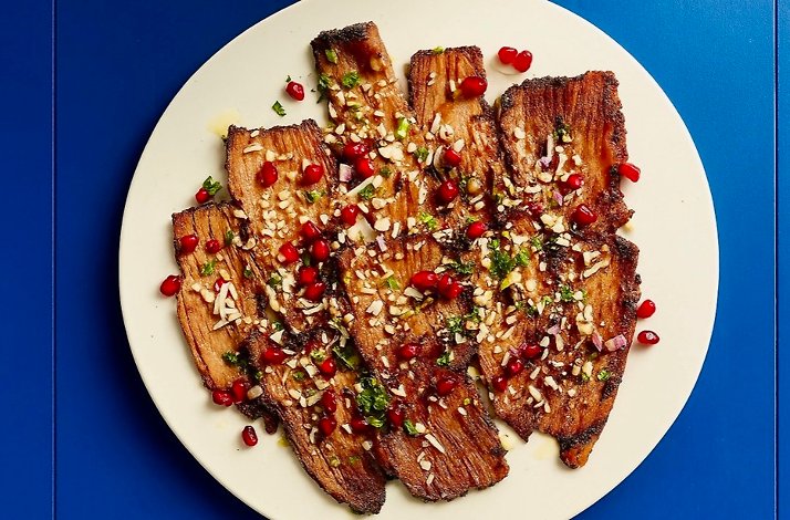 Grilled eggplant at le dräQ, garnished with pomegranate arils, chopped pine nuts, minced herbs, and a glossy dressing.