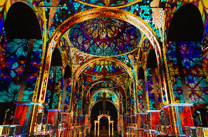 Westminster Cathedral’s nave filled with spectators, as the entire interior glows with light projections during the Luminiscence show.