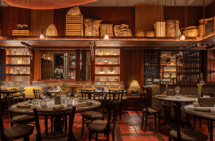 The Spice Market restaurant interior at the Anantara Siam Bangkok Hotel, featuring a warm, wooden-paneled design.