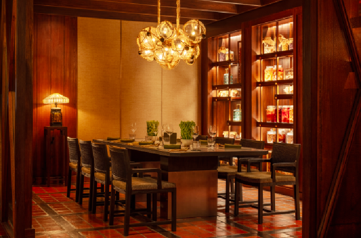 The Spice Market restaurant interior at the Anantara Siam Bangkok Hotel, featuring a warm, wooden-paneled design.