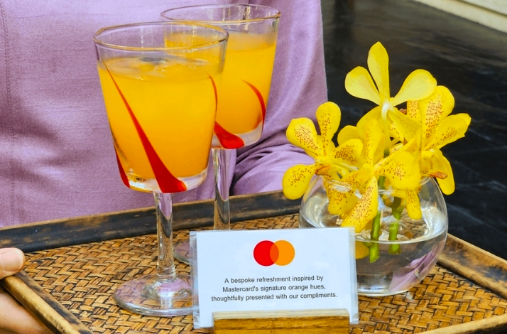 Complimentary orange drinks with yellow orchids on a tray.