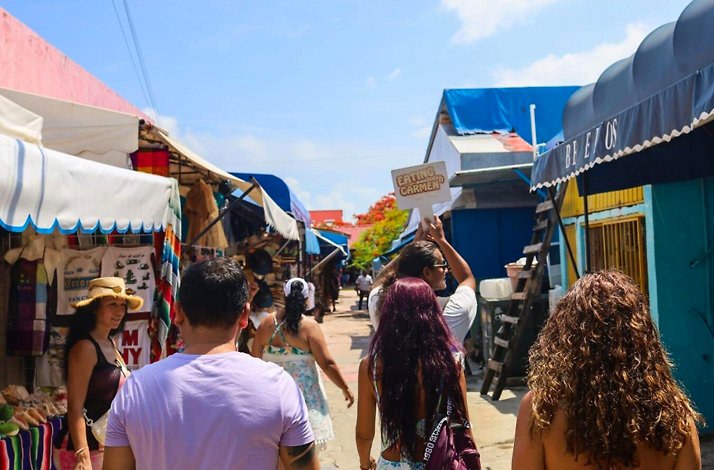 Group walking through colorful local market stalls in Cancun during a food tour, discovering authentic crafts, flavors, and everyday traditions.