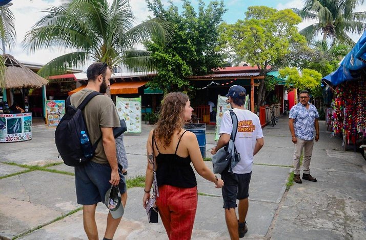 Small group walking through colorful local streets and markets in Cancun, experiencing authentic culinary culture on a guided food tour.