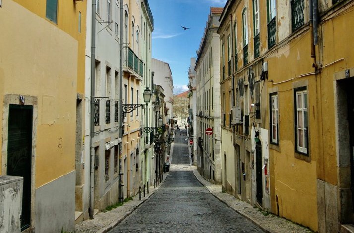 Historic cobblestone street in Lisbon's Bairro Alto district during a guided walking tour.