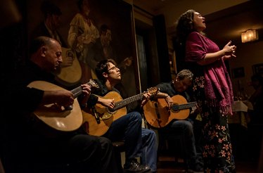 Traditional fado musicians and singer performing live at Adega Machado in Lisbon.