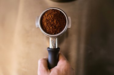 Espresso portafilter filled with finely ground coffee.