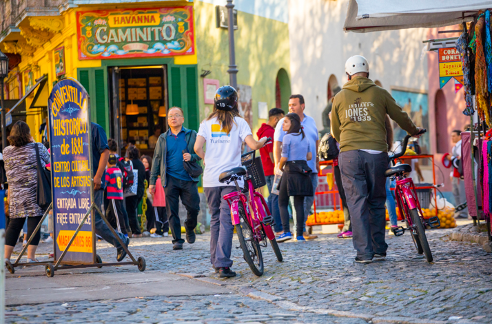 Visitors explore colorful Caminito street in La Boca, Buenos Aires, during a guided cultural tour.